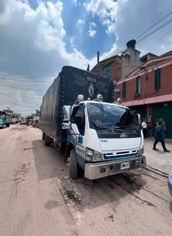 Cami&oacute;n de estacas encarpado, detenido para cargue en una calle de Bogot&aacute;